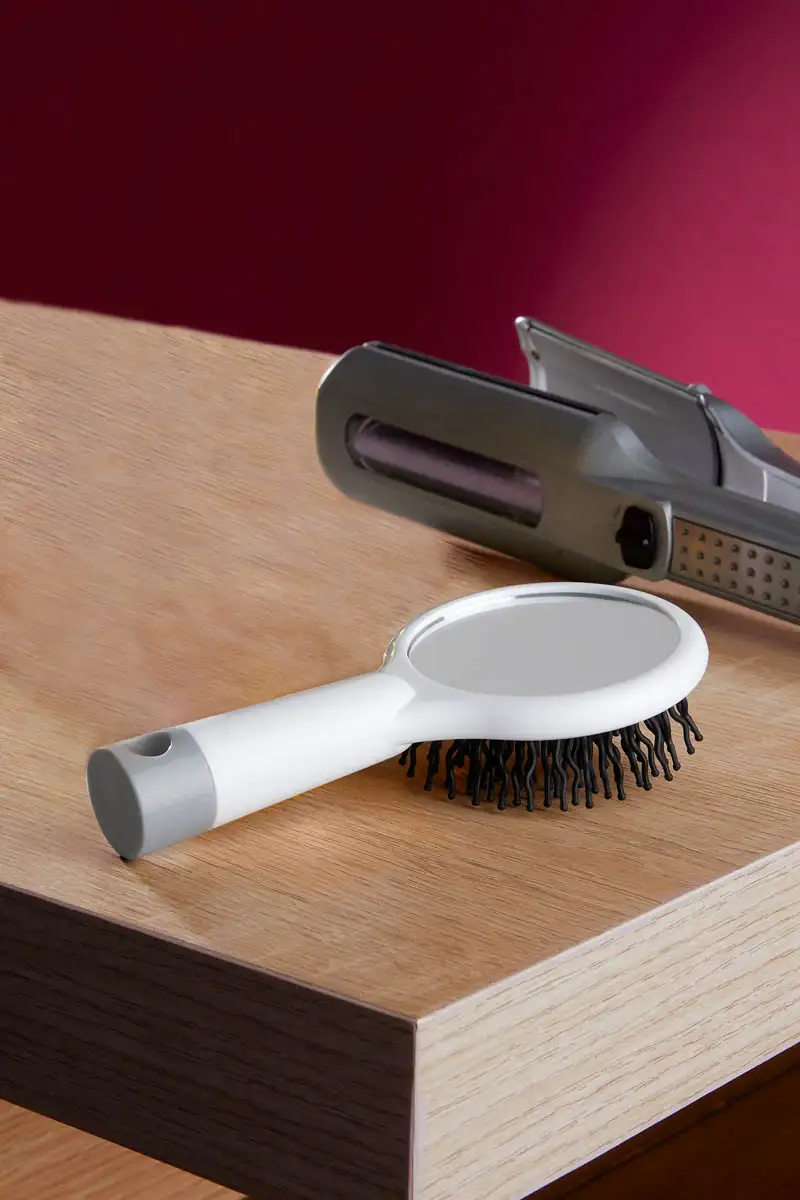 Cepillo anti-frizz con espejo integrado.